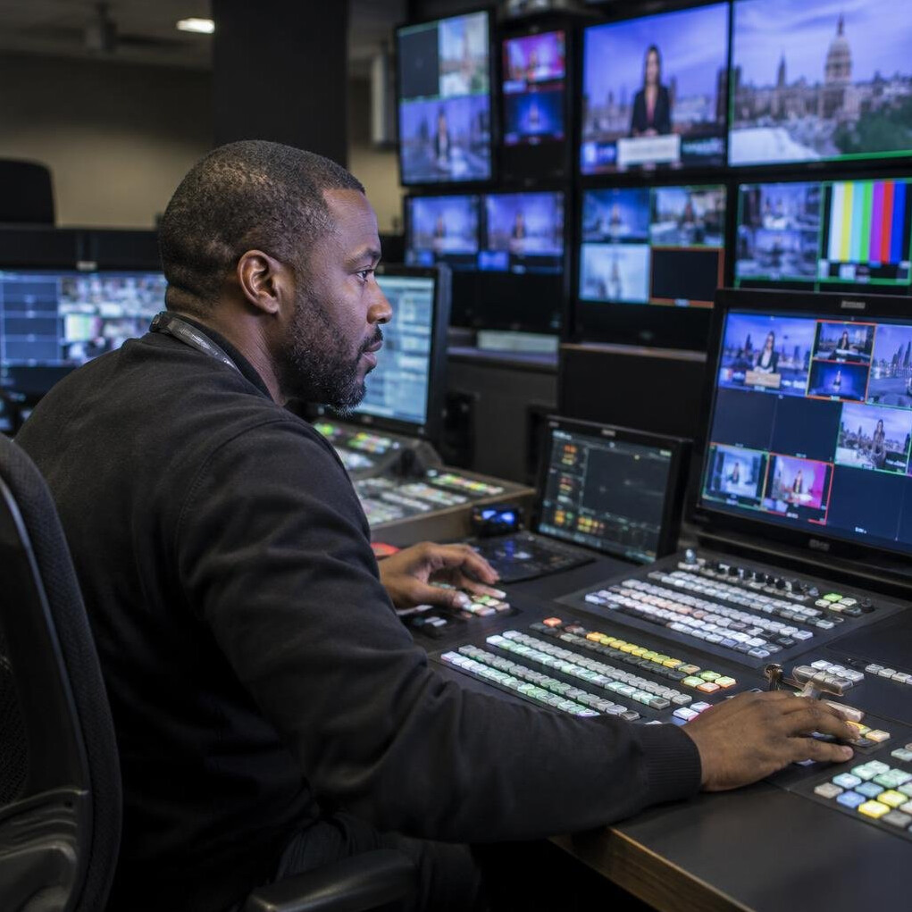 Man at vision mixing desk in a television production gallery